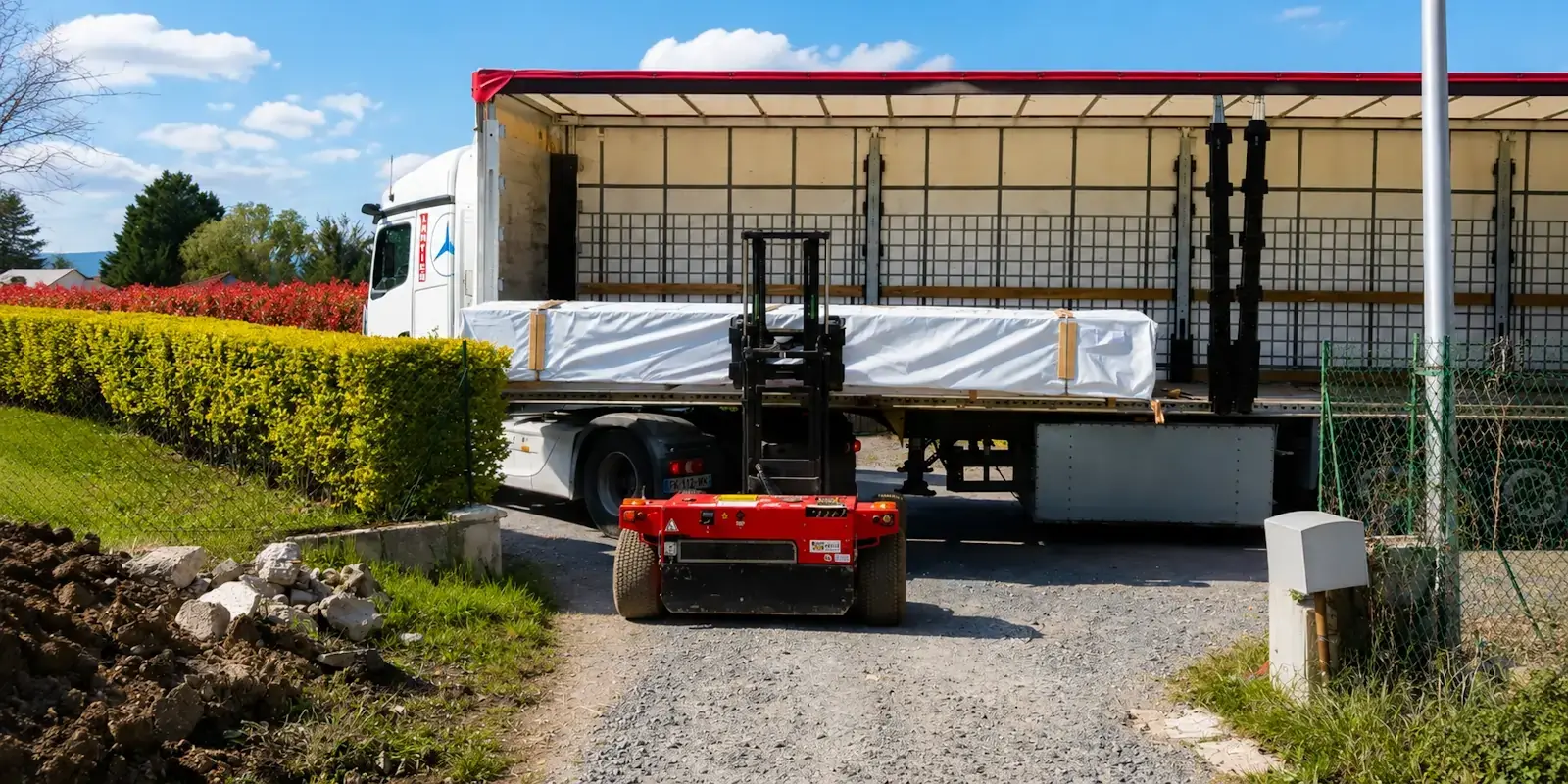 Chargement d'un chalet en kit sur un camion semi-remorque pour une livraison sécurisée partout en France par STMB Construction.