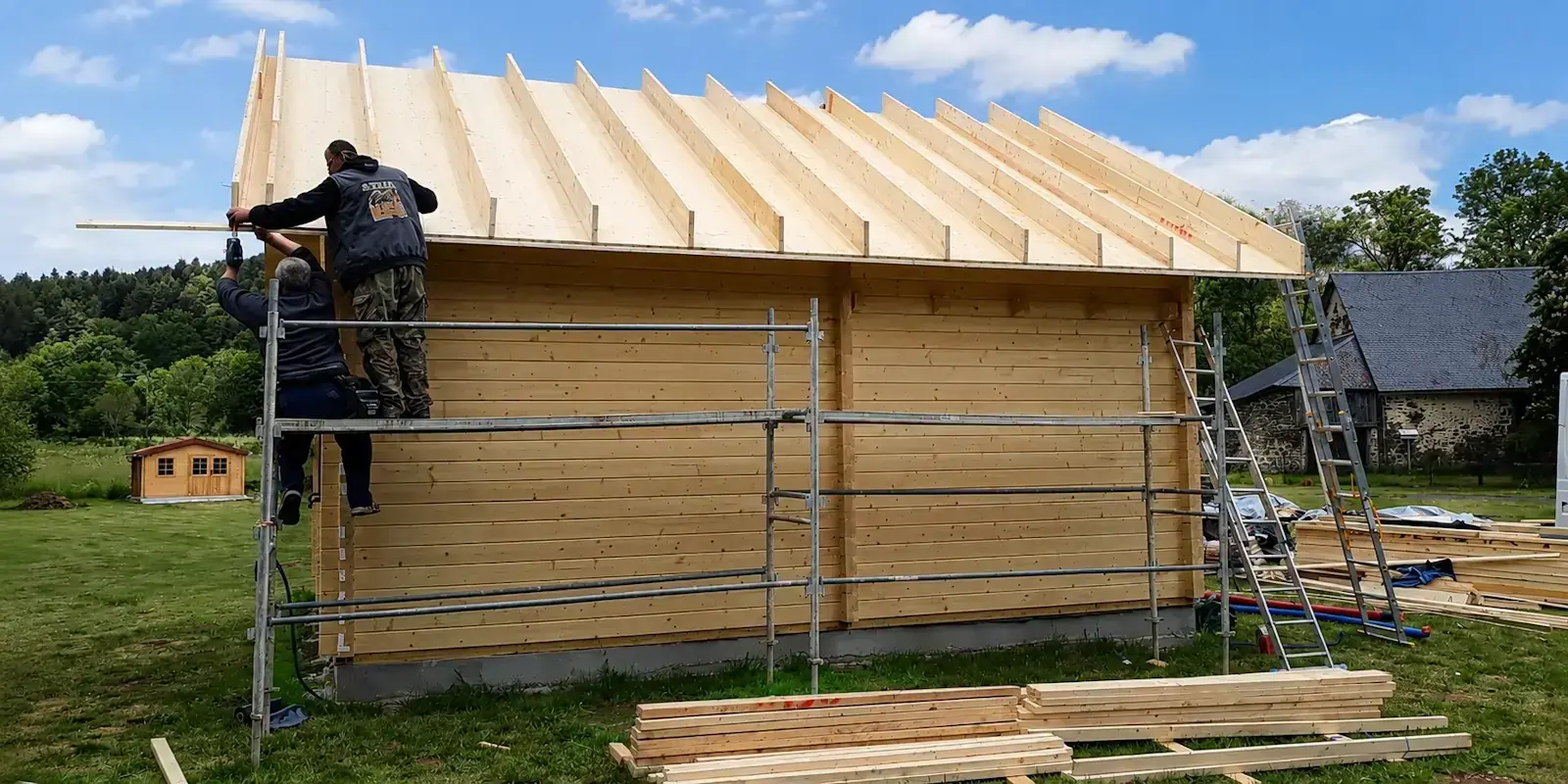 Montage professionnel d'un chalet en bois par les équipes de STMB Construction.