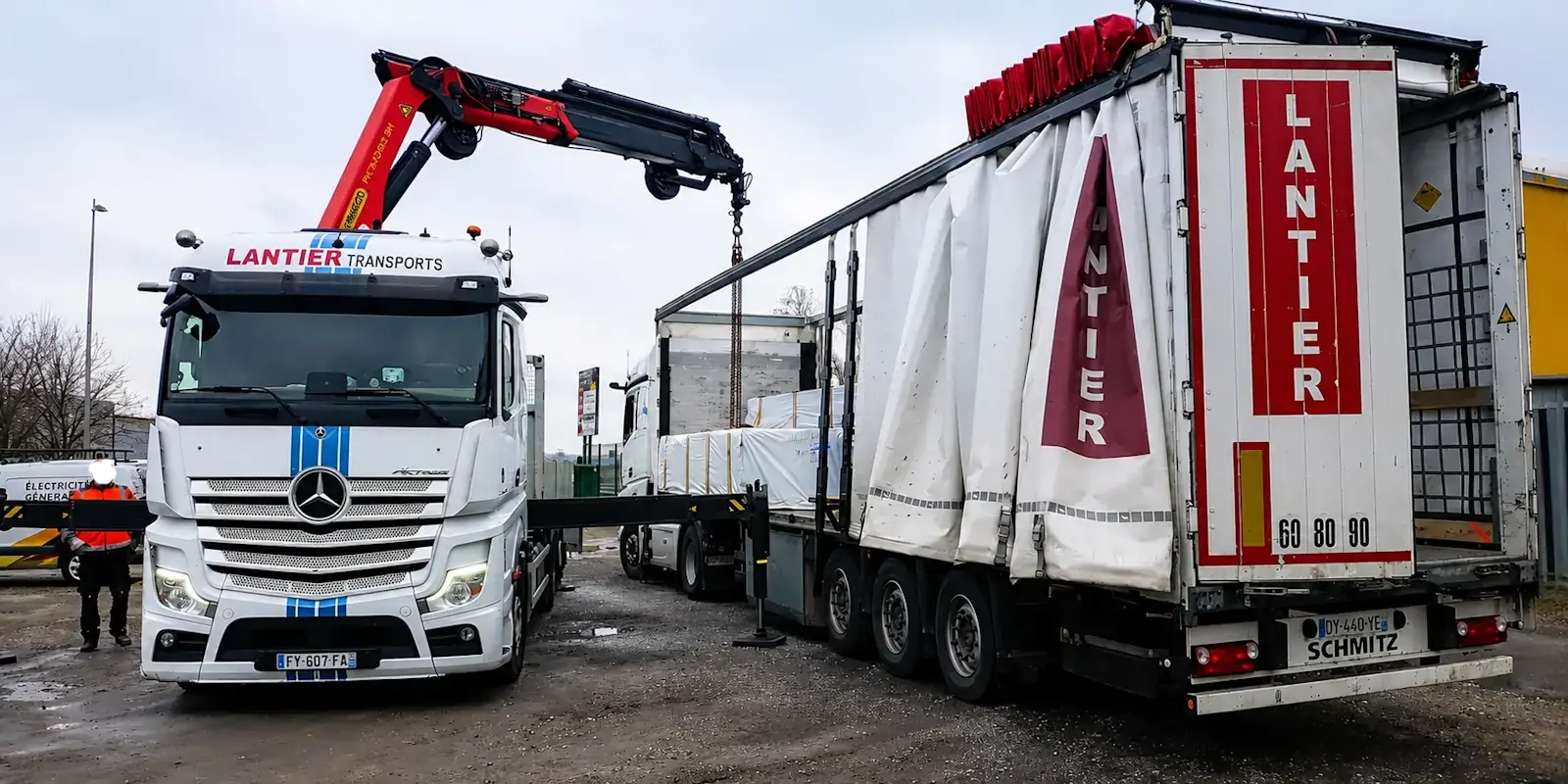 Chargement d'un kit chalet bois dans un camion de transport spécialisé pour une livraison à domicile sécurisée.